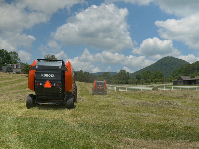 2 New Holland Tractor with Baler in Field