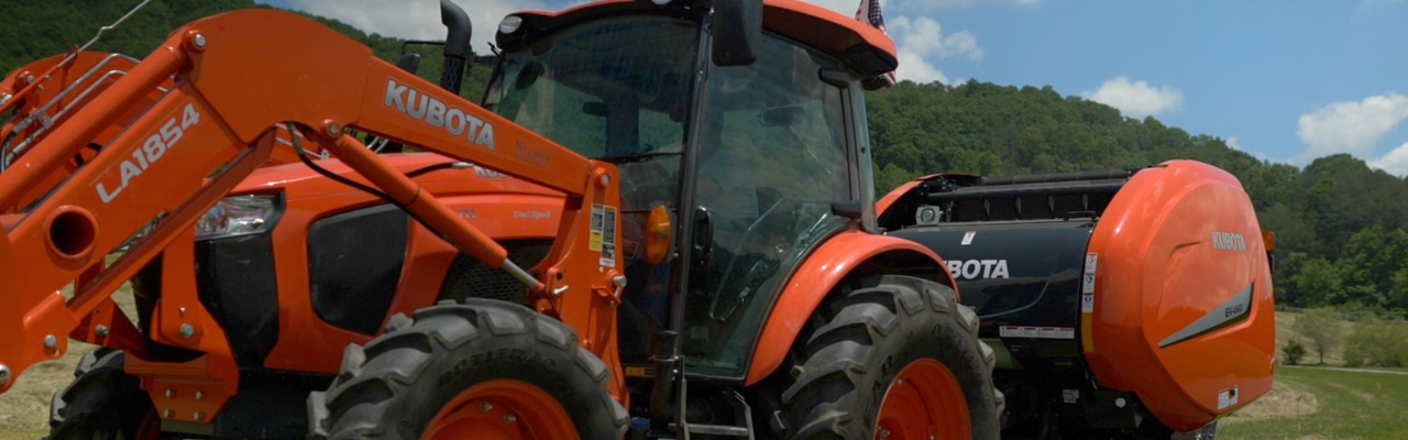 Untitled (1280 x 400 px) Kubota Tractor in Field with Hay Bale