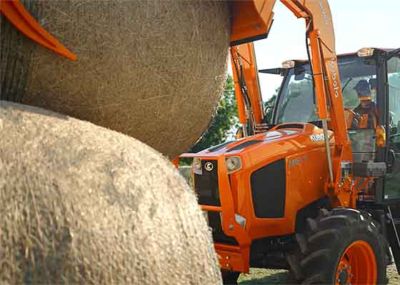 Kubota tractor working with hay bales