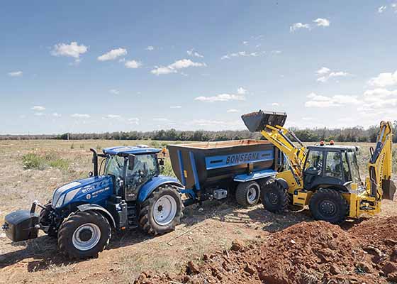 A New Holland construction site with tractor, trailer and loader 