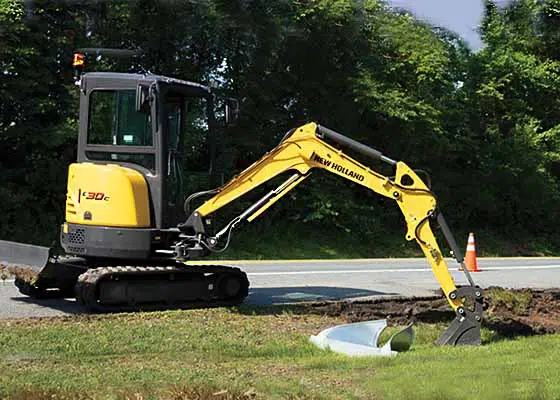 New Holland Excavator near road/grass