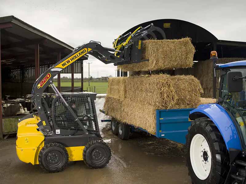 New Holland skid steer loading hay.