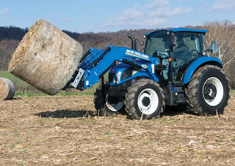 New Holland Tractor Lifting a Hay Bale
