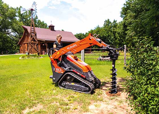 Woman running skid steer auger